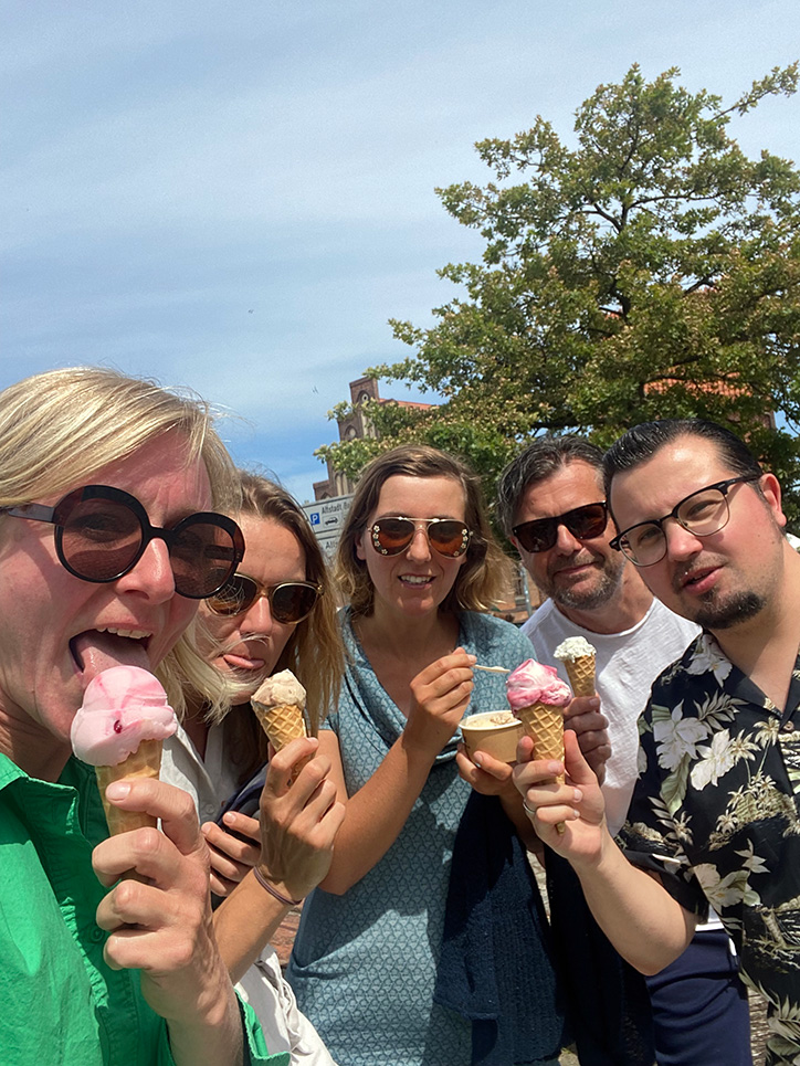 Kati, Sandra, Fränze, Markus und Eric von den Lachsen genießen gemeinsam ein Eis in der Sommersonne in Wismar.